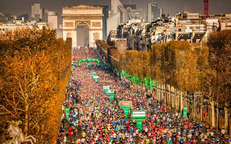 Correr en París: sitios donde entrenar, carreras populares y maratones 12 Corredores de la Maratón de París pasando por Campos Elíseos y Arco de Triunfo