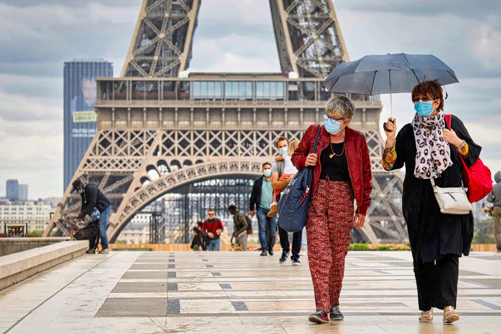 Viajar París covid en Francia: turistas con mascarilla en la Torre Eiffel